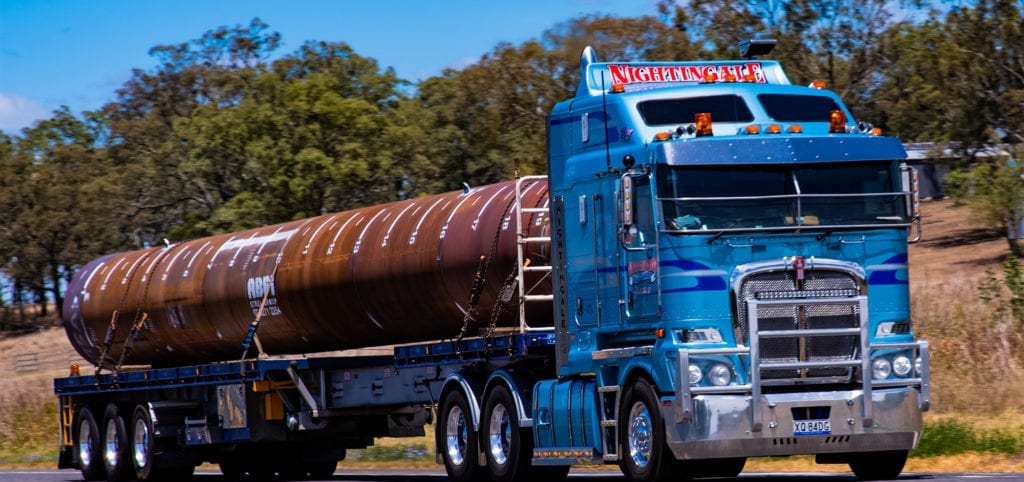 A truck Carrying a Large Steel Pipe